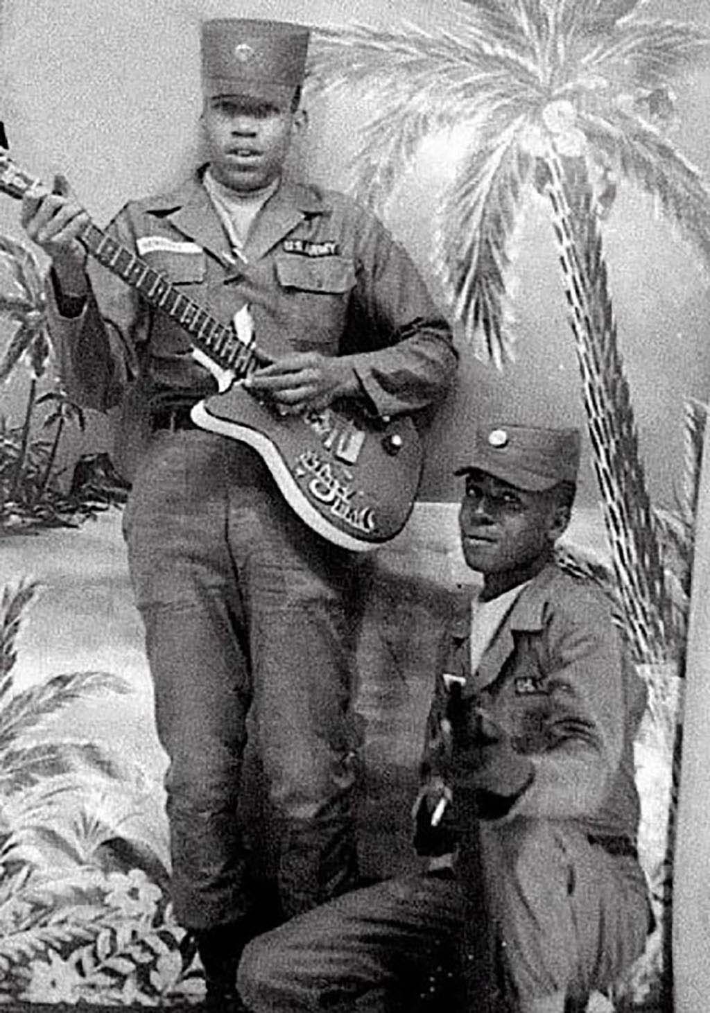 在軍中服役時手拿吉他的Jimi Hendrix（左），約攝於1961年。