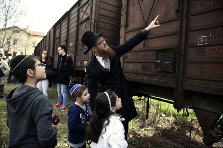 猶太爸爸教導小孩當初受害者是怎麼被火車載走的。